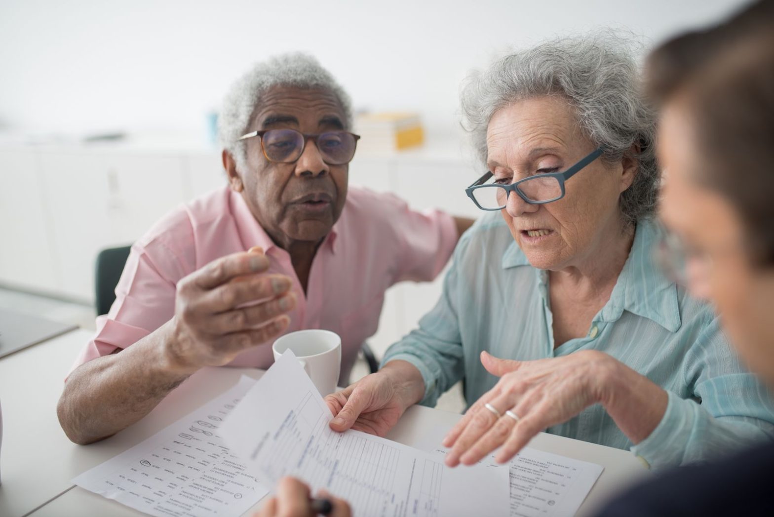 Older couple reviewing paperwork with another person across a table